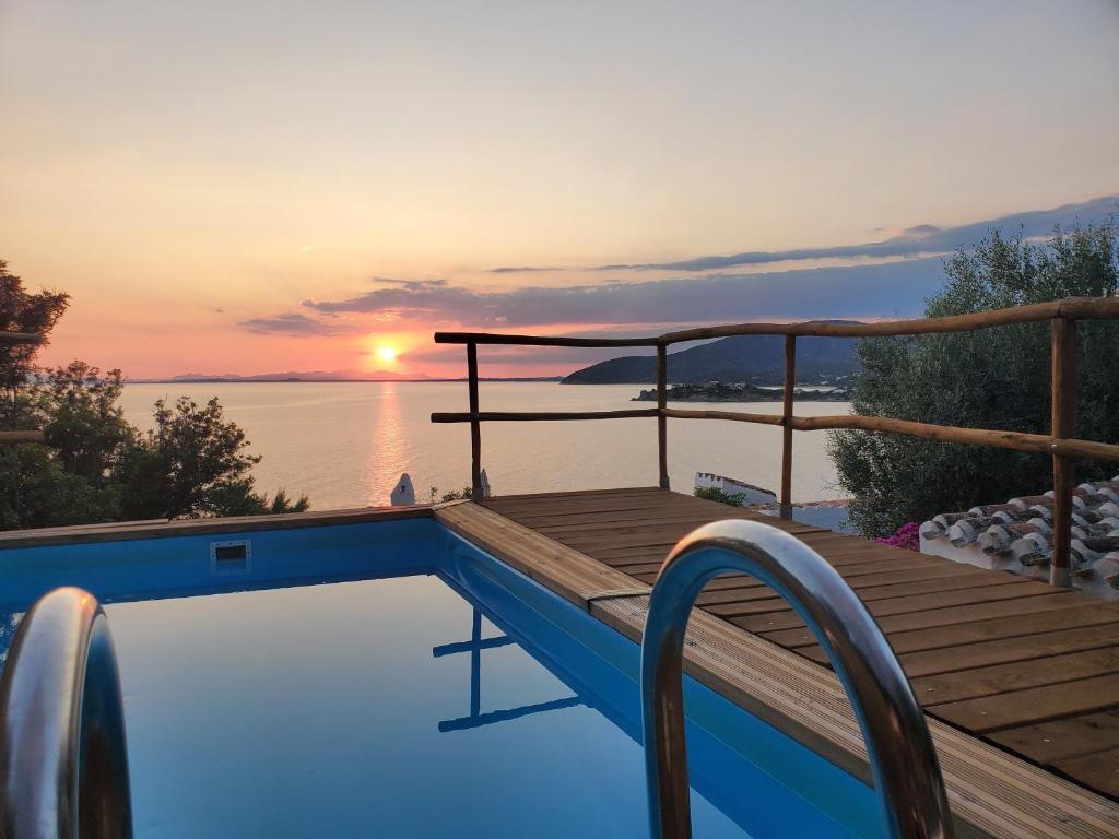 a swimming pool with a sunset in the background at Villa Renata Torre delle Stelle in Torre delle Stelle