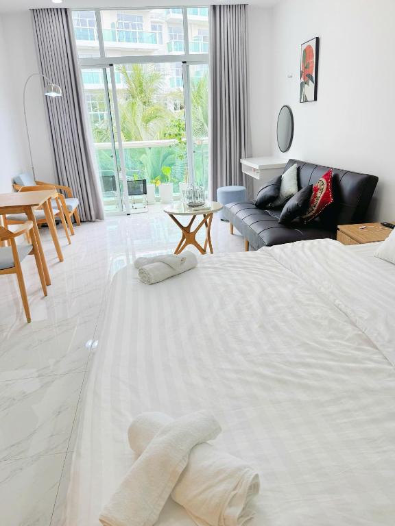 a white bedroom with a large bed and a couch at ocean vista gio bien in Ấp Phú Tịnh (2)