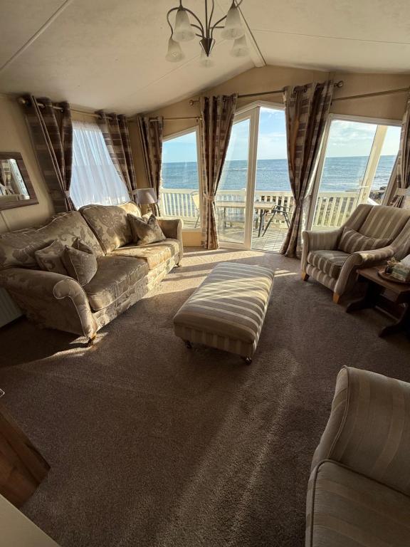 ニュービギン・バイ・ザ・シーにあるNo13 Seaview Holiday Homeのソファと大きな窓のあるリビングルーム