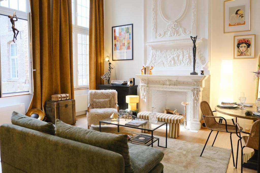 un salon avec un canapé et une cheminée dans l'établissement La cour d Anvers, à Dieppe