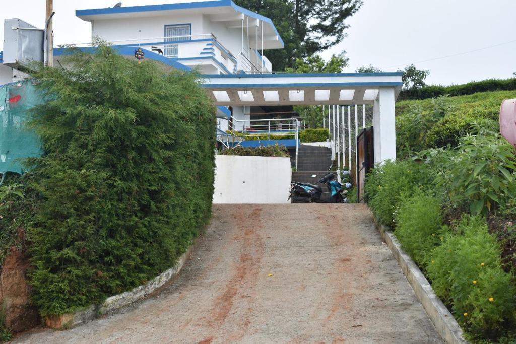 a driveway leading to a house with a gate at diamond hill view cottage in Ooty