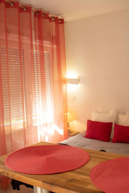 a bedroom with a bed and red mats on a table at Studio - Piscine, proche du golf in Juvignac