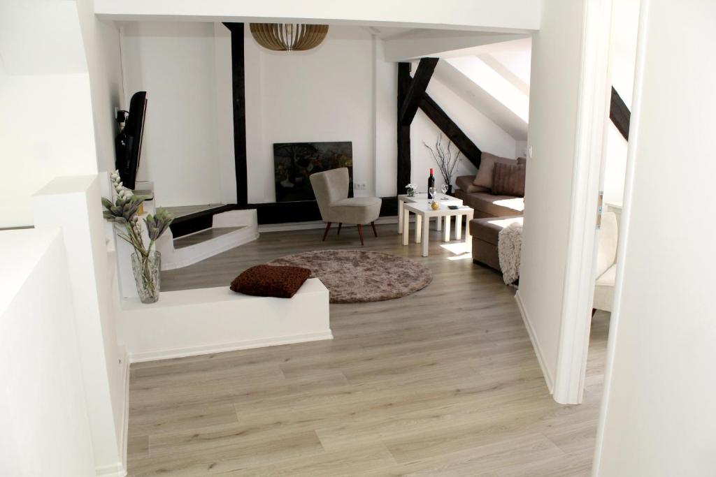 a living room with white walls and wood floors at Miaap Apartments in Sarajevo