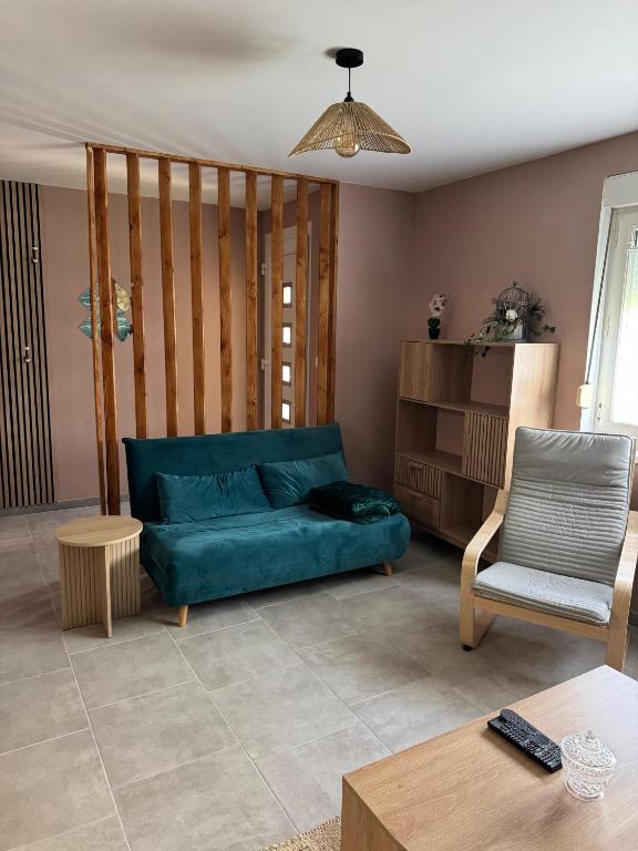 a living room with a blue couch and a chair at Gite accueillant et confortable in Etreux