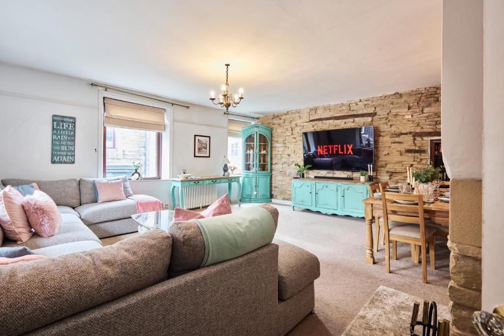a living room with a couch and a table at Above Rubies - Cross Cottage, Luxury, Dog Friendly in Haworth
