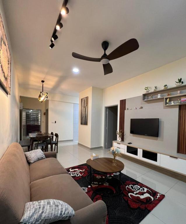 a living room with a couch and a ceiling fan at Highland Chill Retreat in Tanah Rata