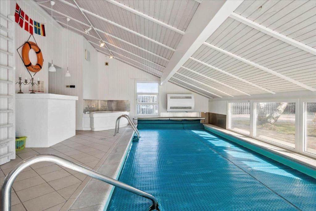 a large swimming pool in a building with an indoor swimming pool at TV1170-Jerup-Engblommen-7 in Jerup