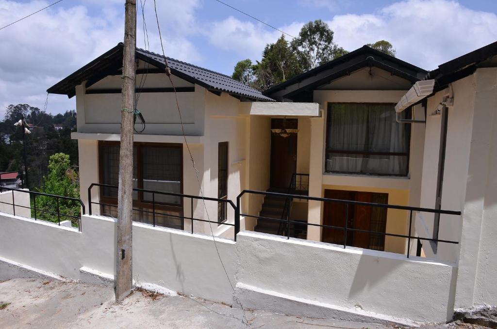 a house with a balcony with a pole at ARYASREE homestay in Kodaikānāl