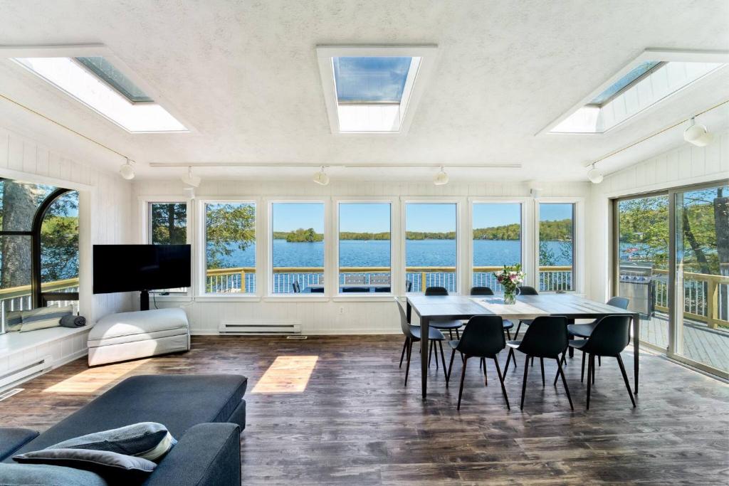 a living room with a table and chairs and windows at Dream Lakefront Escape + Beach/Ski/Golf near NYC in Highland Lakes