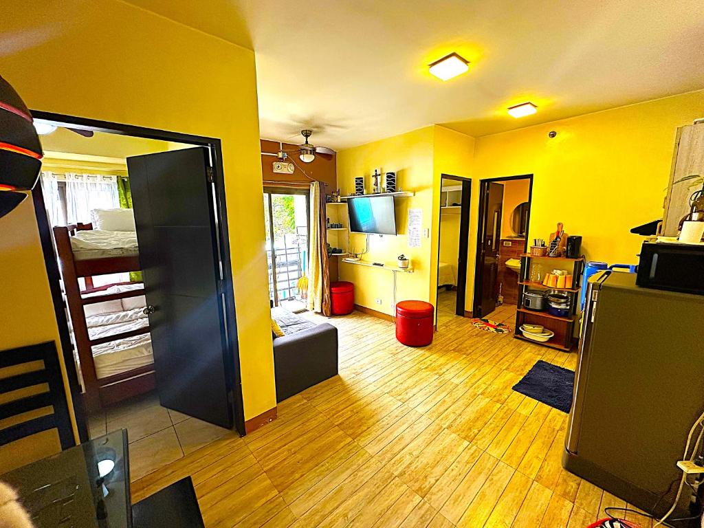 a living room with yellow walls and a wooden floor at Condo 2Bedroom near Session with Free Own Parking in Baguio