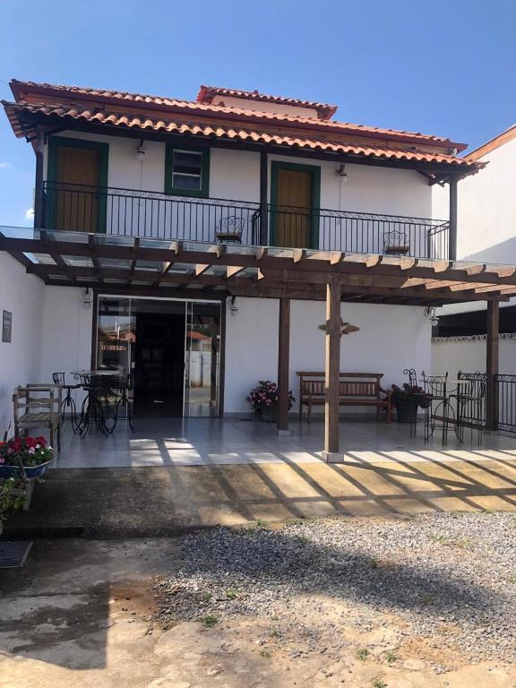 a building with a deck with tables and chairs at Pousada Joaninha in Tiradentes