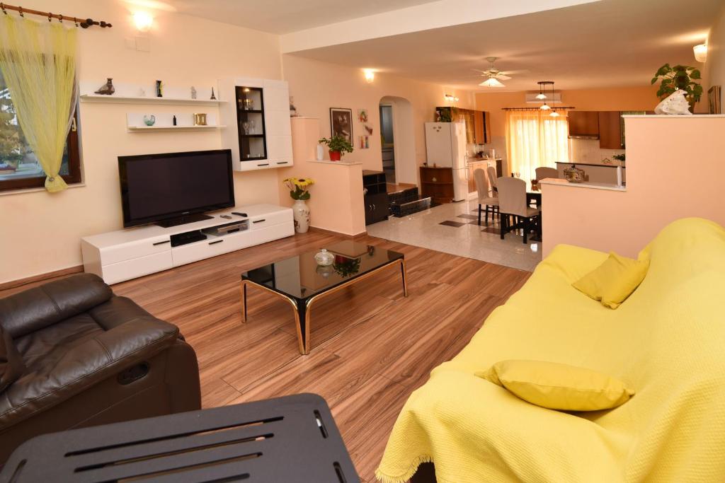 sala de estar con sofá amarillo y TV en Apartment Enjoy You, en Split