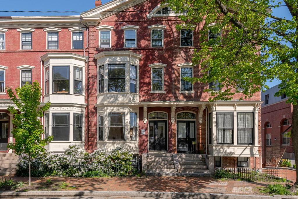 een oud bakstenen huis met witte ramen aan een straat bij The 87th Townhome - Local Landmark Property in Portland