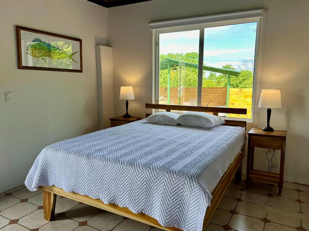 a bedroom with a bed and a large window at Casa Blanca Manuel Antonio B3, Central, Pool, Gated in Manuel Antonio