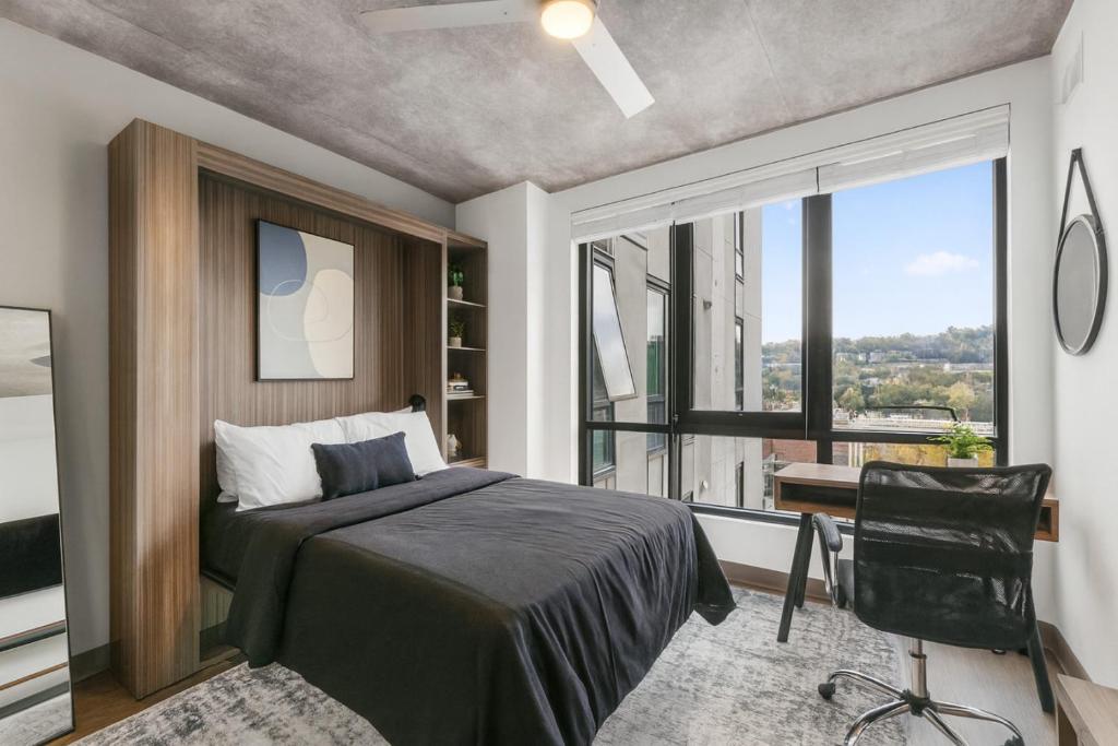een slaapkamer met een bed, een bureau en een raam bij Cozy Murphy Hideaway Studio 14th in Birmingham