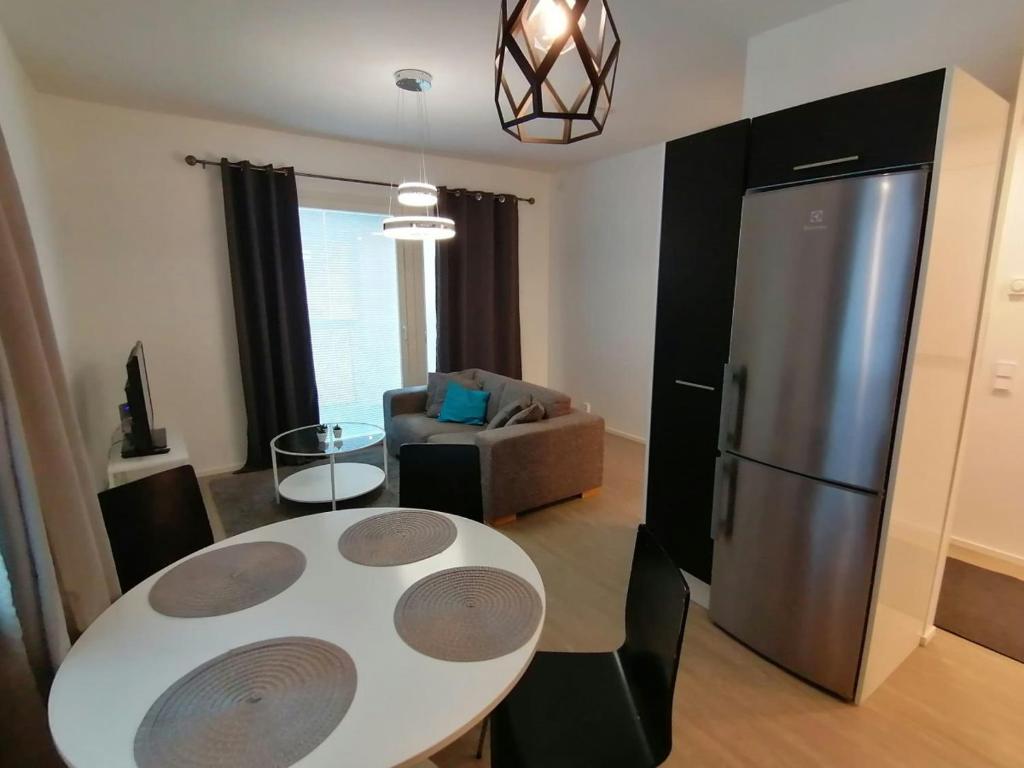 a living room with a white table and a refrigerator at Central Apartment for 2 with Sauna in Kittilä