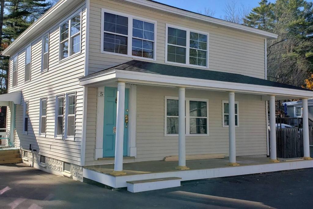 a white house with a blue door on a street at Little Miss Cottages - 5 Seaview House in Old Orchard Beach
