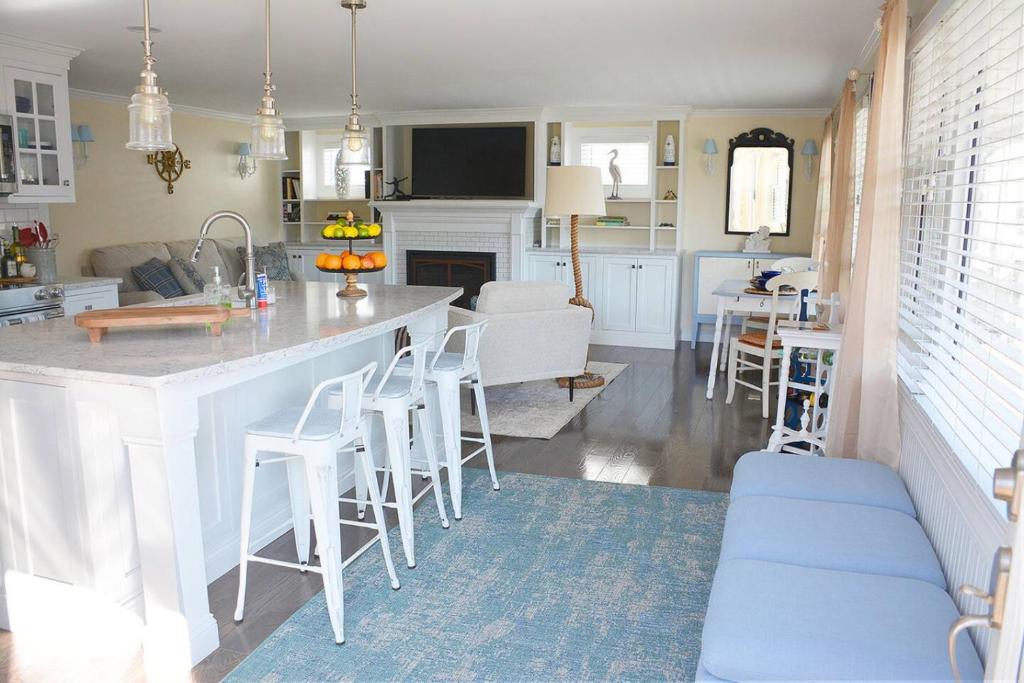 a kitchen and living room with a large white island at Little Miss Cottages - 68 East Grand Luxury Condo in Old Orchard Beach