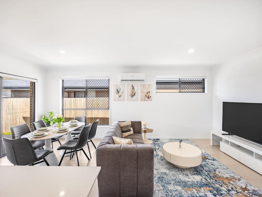 un salon avec un canapé et une table dans l'établissement Bright Serenity Family Comfort near Parks and Shops, à Marsden