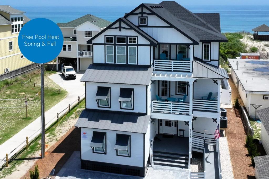 a house with a sign that says free roof test since it is fall at Salty Sunrise - K1224 in Whalebone