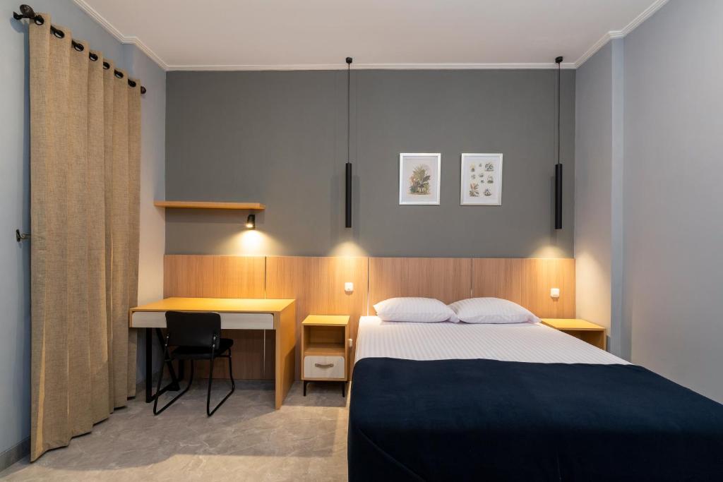 une chambre d'hôtel avec un lit et un bureau dans l'établissement YASA Residence Fatmawati, à Jakarta