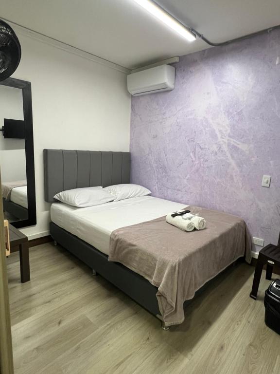 una camera con un letto con una parete viola di Hermoso lugar en laureles estadio cerca la 70 a Medellín