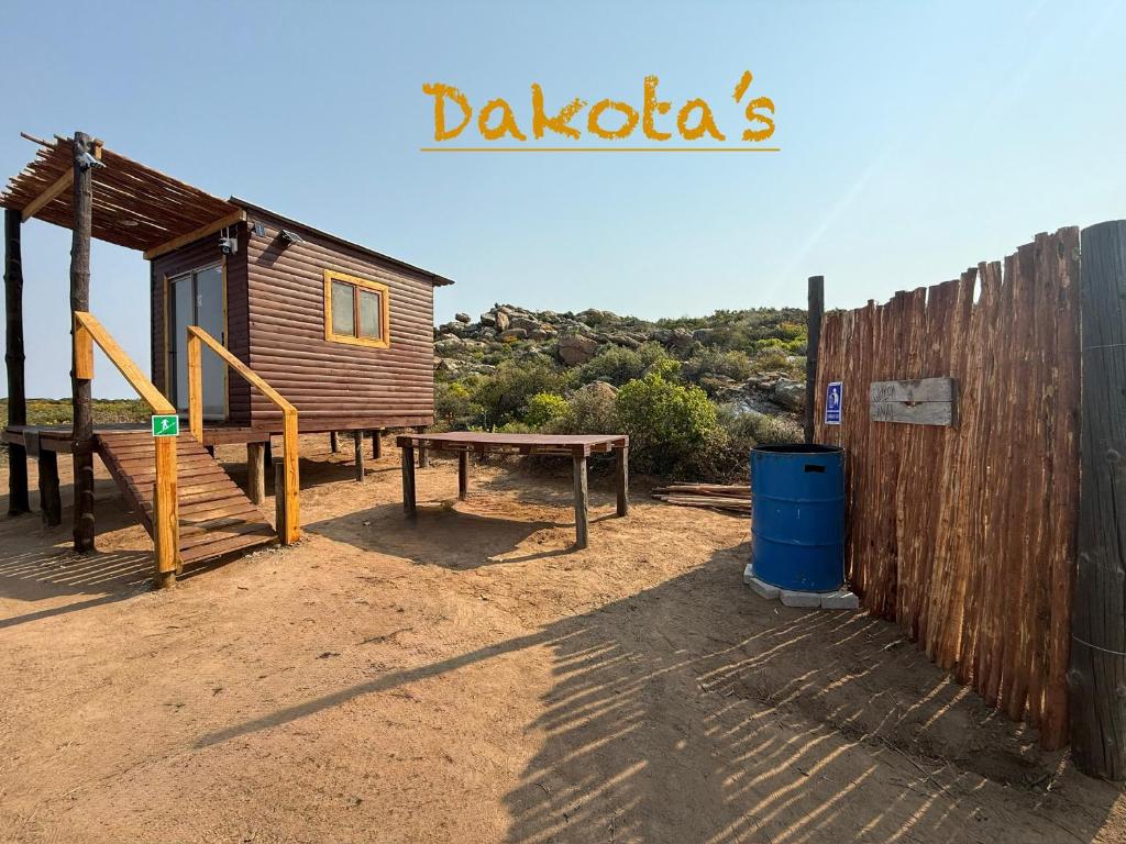 a wooden cabin with a picnic table and a bench at Dakotas offgrid camping in Springbok