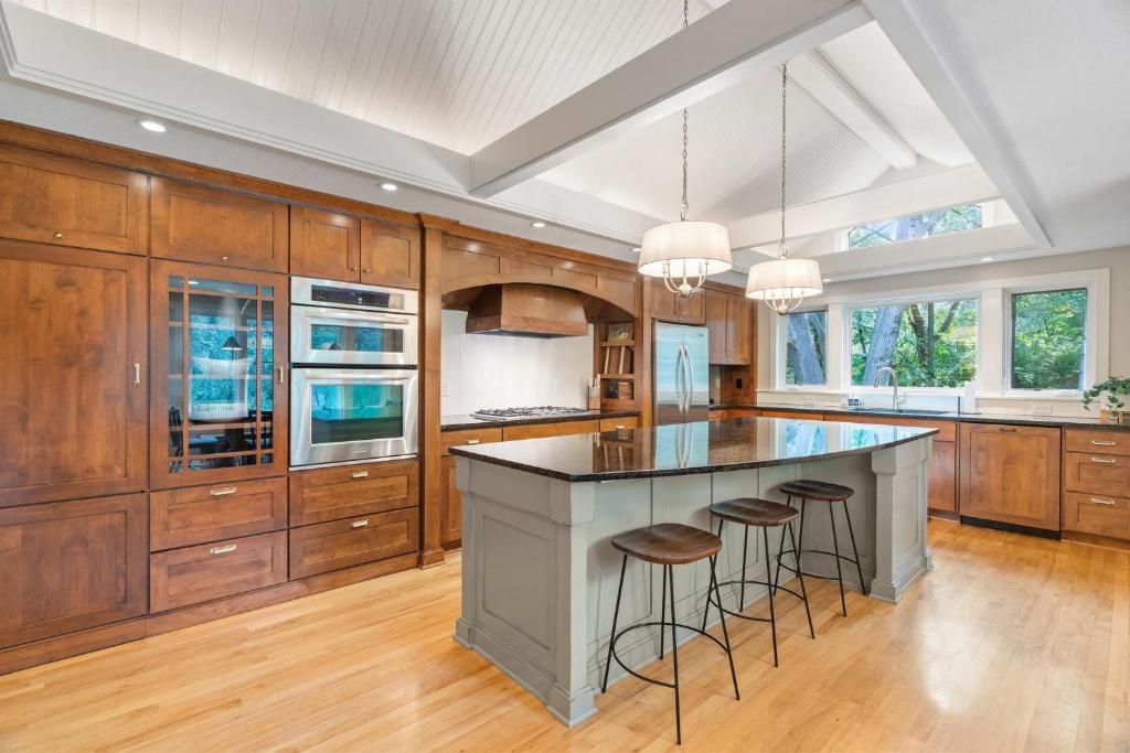 a kitchen with wooden cabinets and a large island with bar stools at Woodland Hollow in Minnetonka