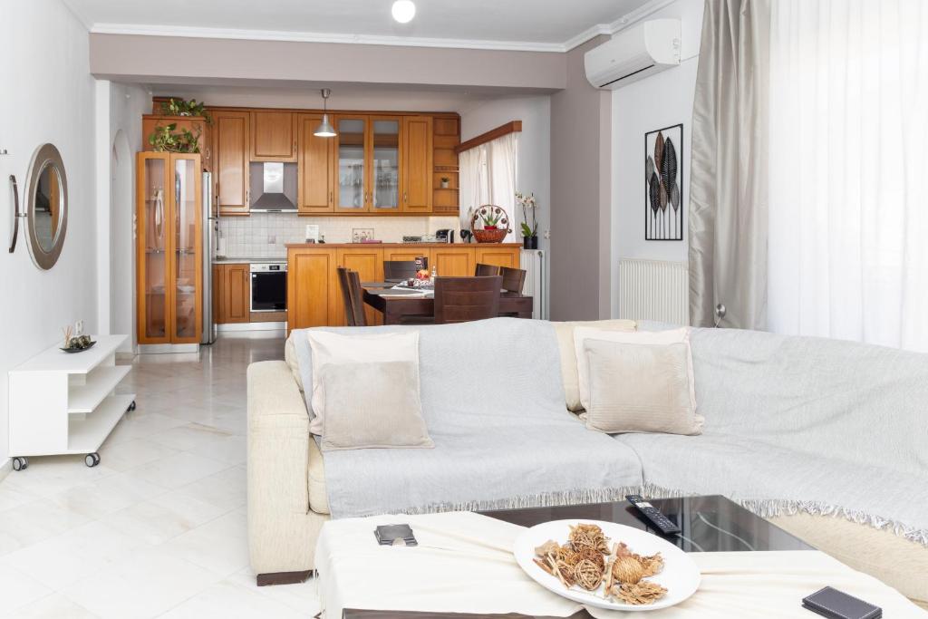 a living room with a white couch and a kitchen at Dolce Far Niente Suite in Kalamata