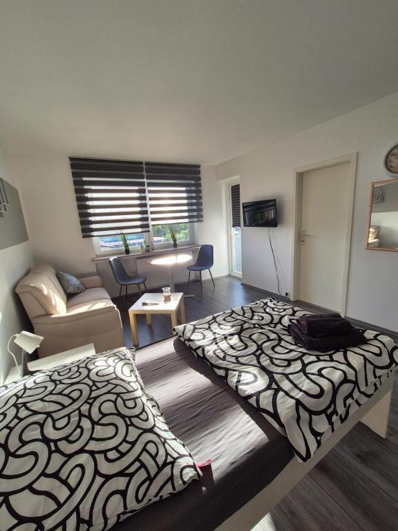 a room with two beds and a living room at Apartment an der Weser in Bremerhaven