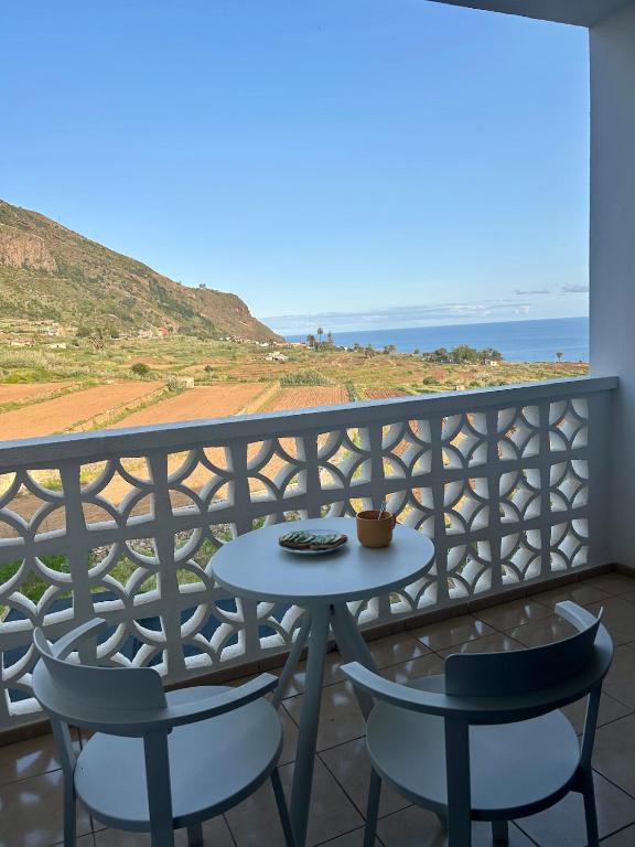 a table and chairs on a balcony with the ocean at Apartamento tranquilo con vistas in Los Realejos