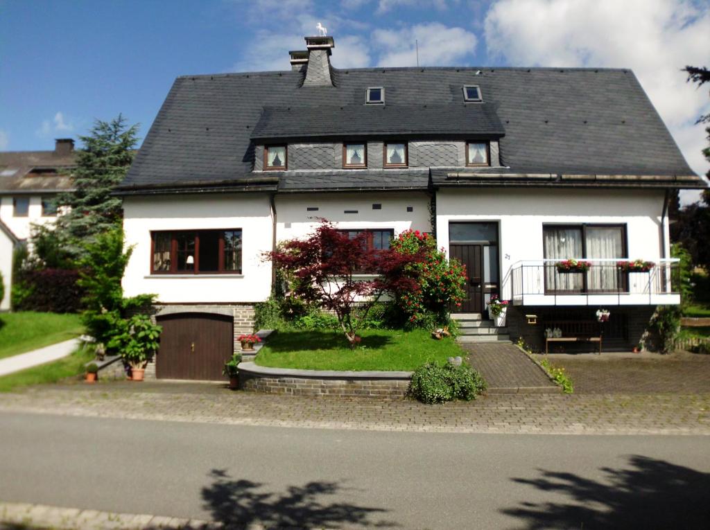 a white house with a black roof at Ferienhaus Suedhang in Winterberg