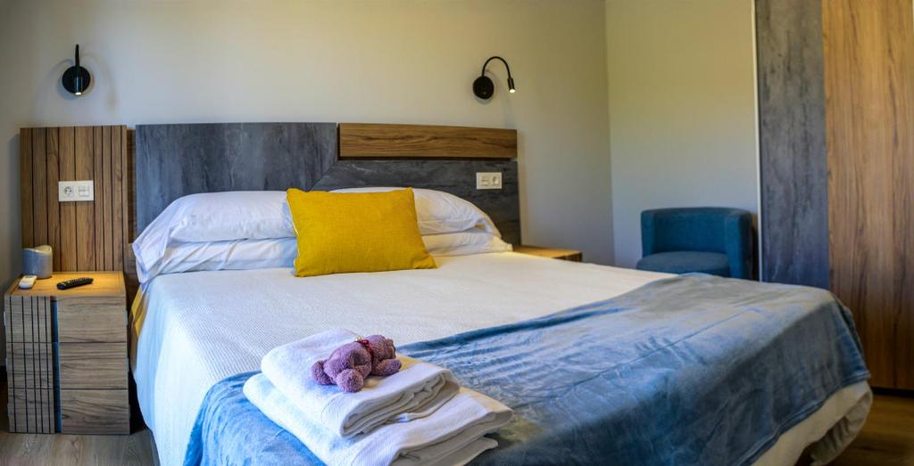 a bedroom with a bed with towels and a teddy bear on it at Apartamentos El Puente in Covarrubias