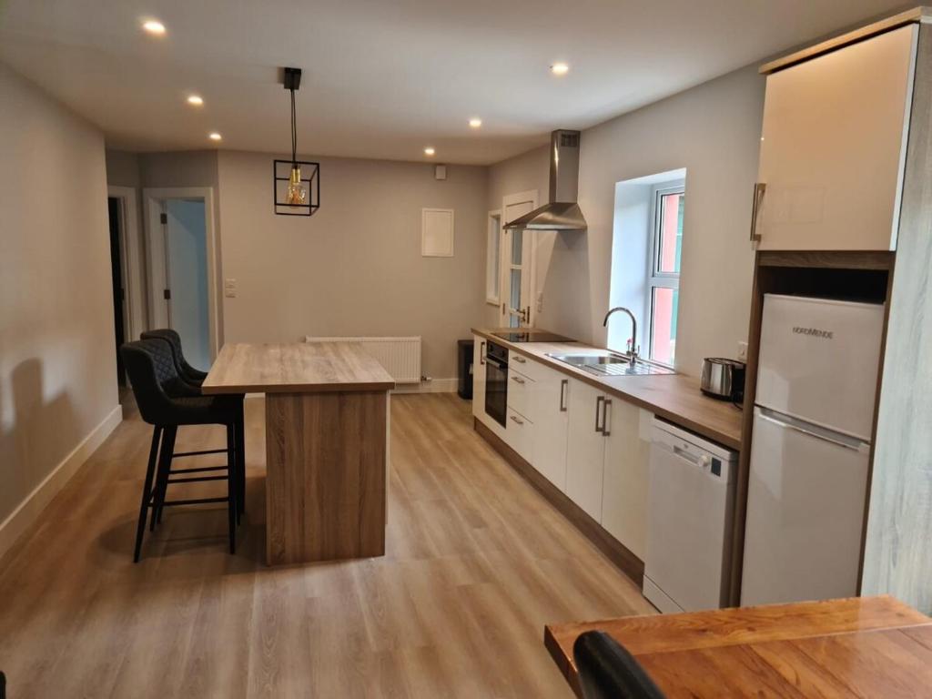 een keuken met een eiland in het midden van een kamer bij Modern 2 bedroom Apartment with River views in Behy Bridge