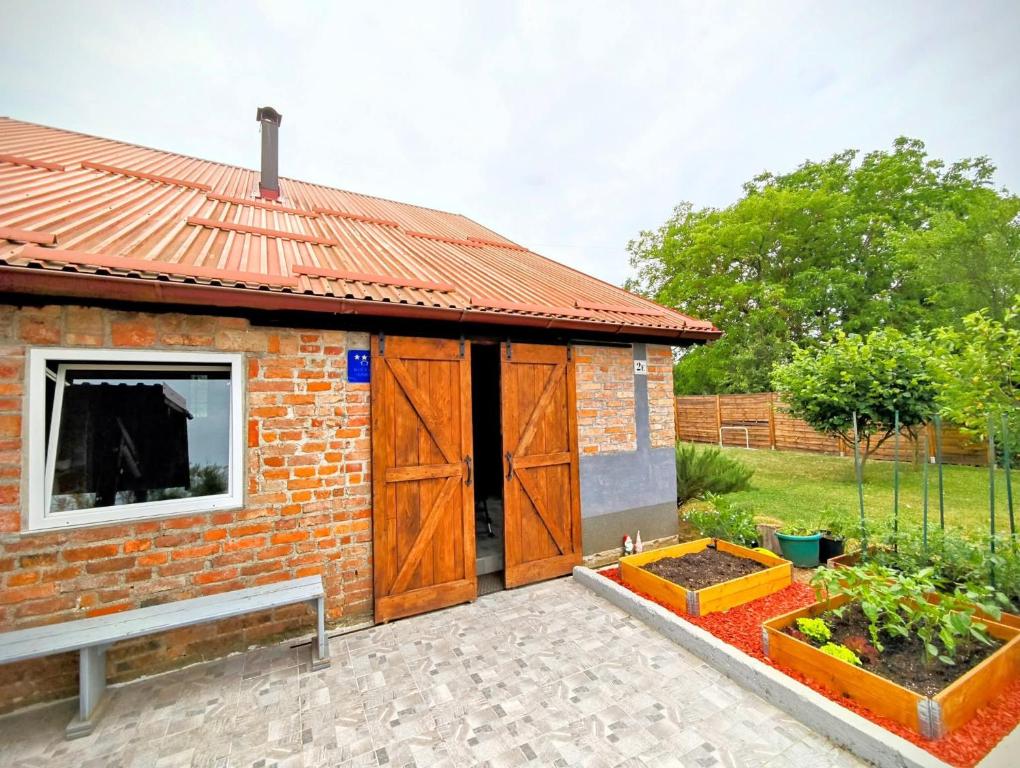 a small brick building with a large wooden door at Charming Cottage Novo Čiče in Novo Čiče