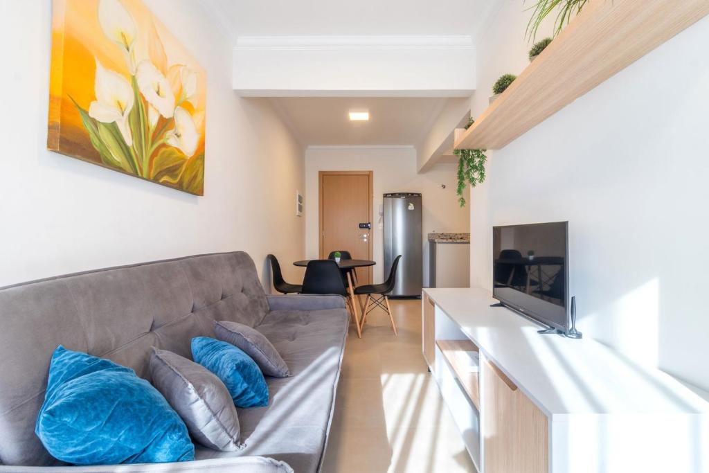 a living room with a couch and a tv at Apto funcional no Centro de Blumenau UG6156 in Blumenau