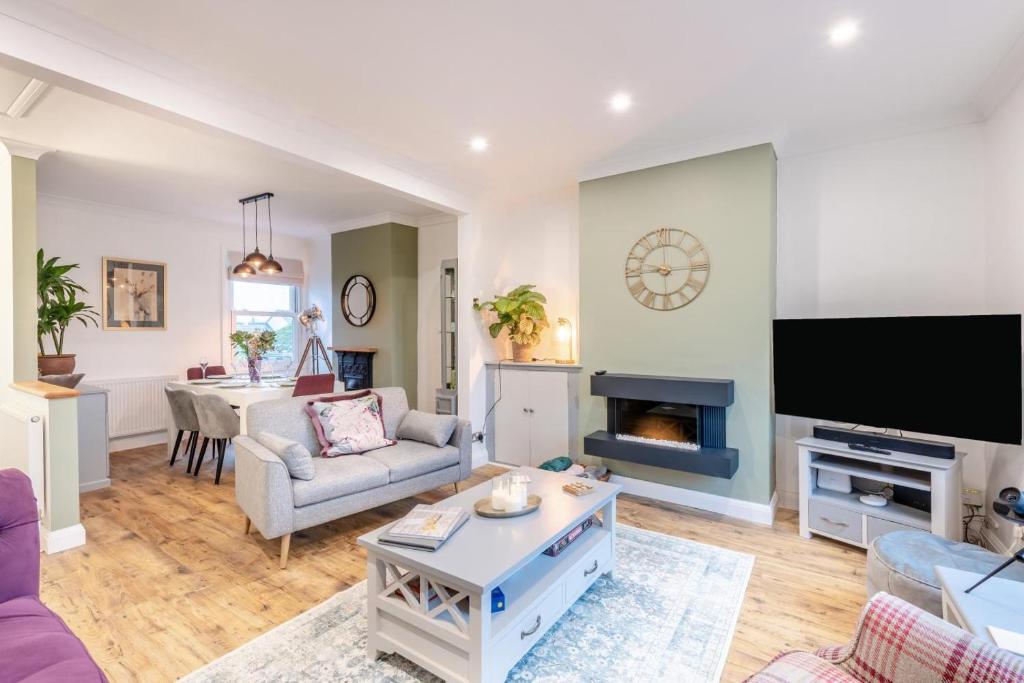 ein Wohnzimmer mit Sofa und Fernseher in der Unterkunft Quayside Cottage in Rye