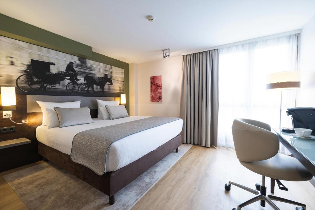 a hotel room with a bed and a desk and a chair at Leonardo Vienna Westbahnhof in Vienna