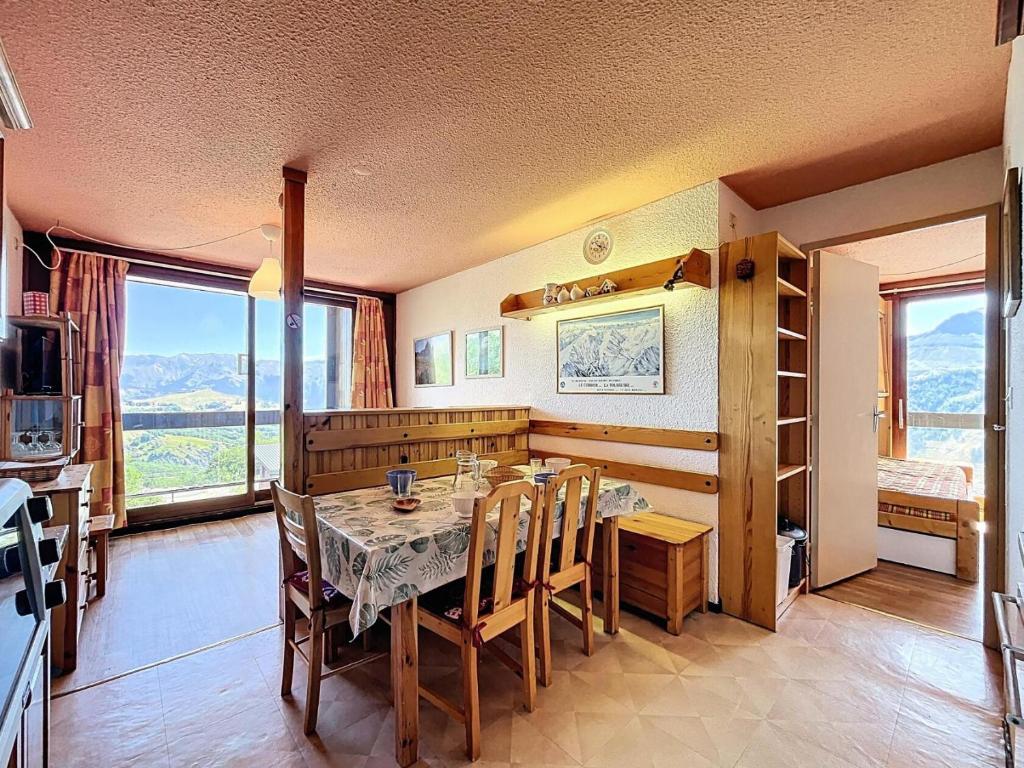 comedor con mesa y algunas ventanas en Résidence Pegase - APPARTEMENT 2 PIECES 5 PERSONNES MAE-9724, en Le Corbier