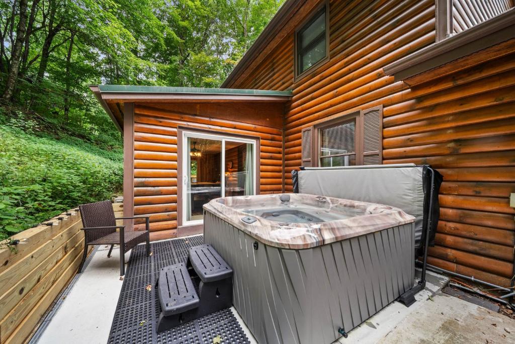 Un jacuzzi en una terraza junto a una casa. en The Smore the Bearier, en Zionville