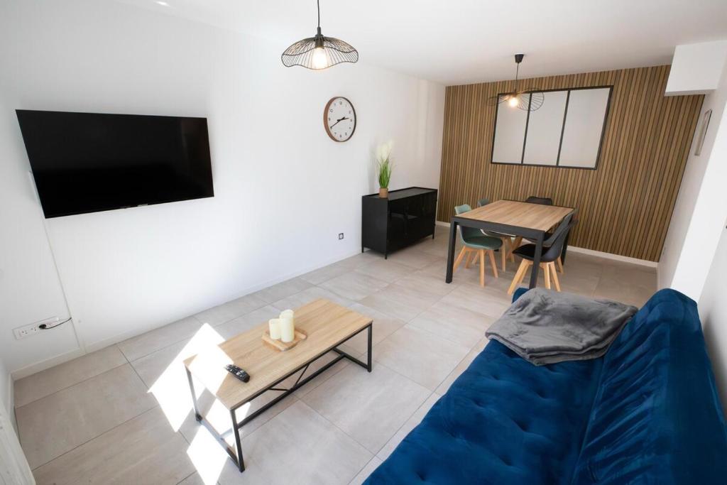 BreslesにあるAppartement de charme avec extérieurの青いソファとテーブルのあるリビングルーム