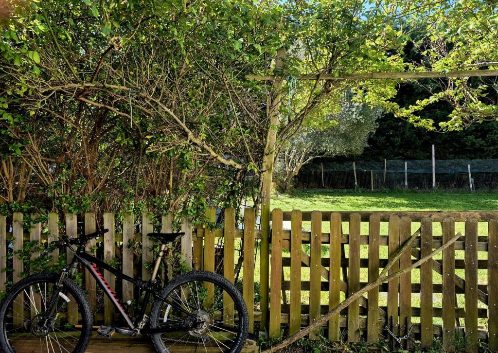 una bicicletta parcheggiata accanto a una recinzione di legno di Bed in mixed dorm ideal for bikes and walkers on the camino a Zizur Mayor