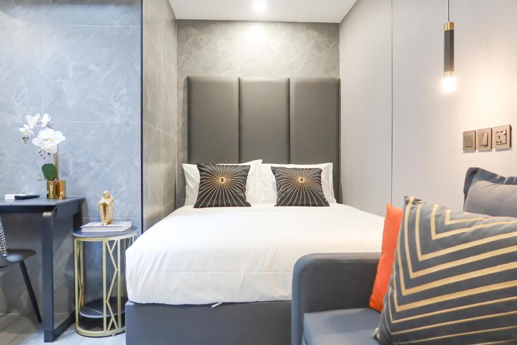 a bedroom with a large bed and a chair at Comfy 2 Bedroom Apartment by ReCharge in Singapore