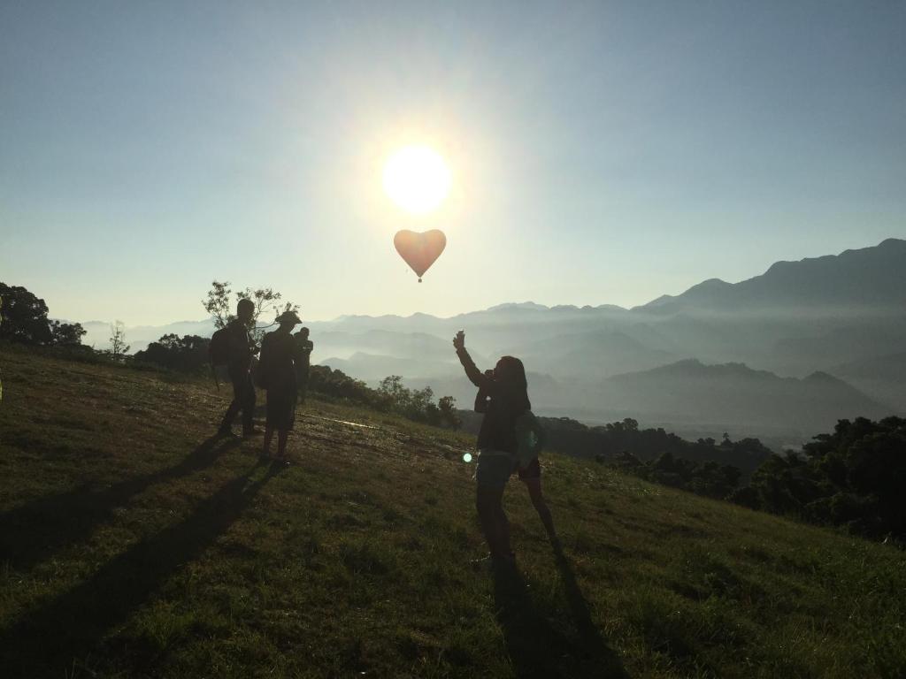 a group of people standing on a hill with a heart balloon at Winnie Homestay in Longtian
