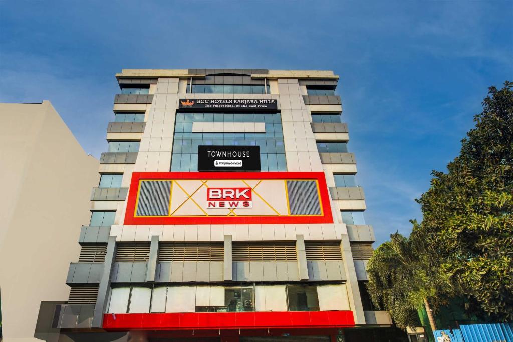 a tall building with a large sign on it at Super Townhouse Rcc Hotel Banjara Hills in Hyderabad