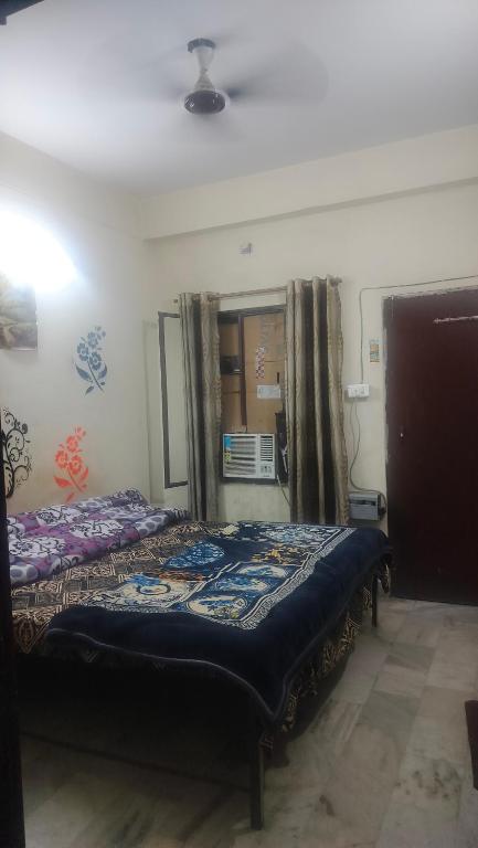 a bedroom with a bed in a room with a window at Raghunath bhawan in Haridwār
