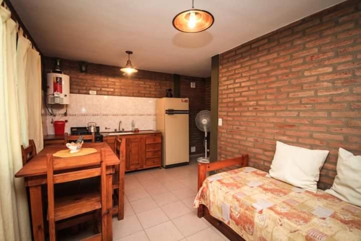 a kitchen with a bed and a table in a room at Nélida Dpto 1 in Villa Carlos Paz