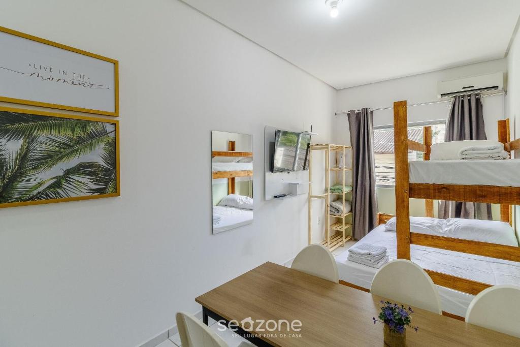 a bedroom with a bunk bed and a table and chairs at Lindos Lofts no Centro de Floripa - FLT in Florianópolis