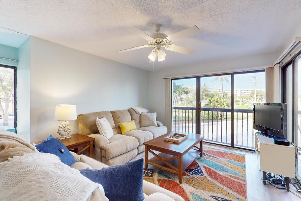a living room with a couch and a tv at Santa Maria Condo 102 in Fort Myers Beach