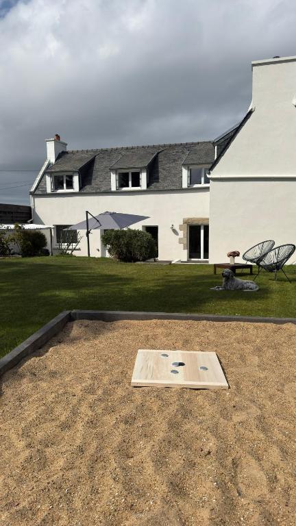 a yard with a table and chairs in front of a house at Ty Glaz - Maison Bord de mer avec jardin, proche plage in Roscoff